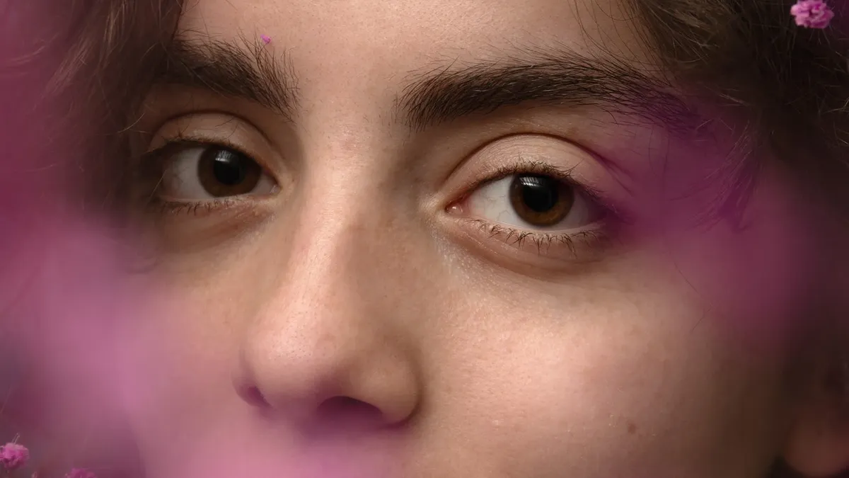 Incanto: primo piano degli occhi di Sole con riflessi di luce viola