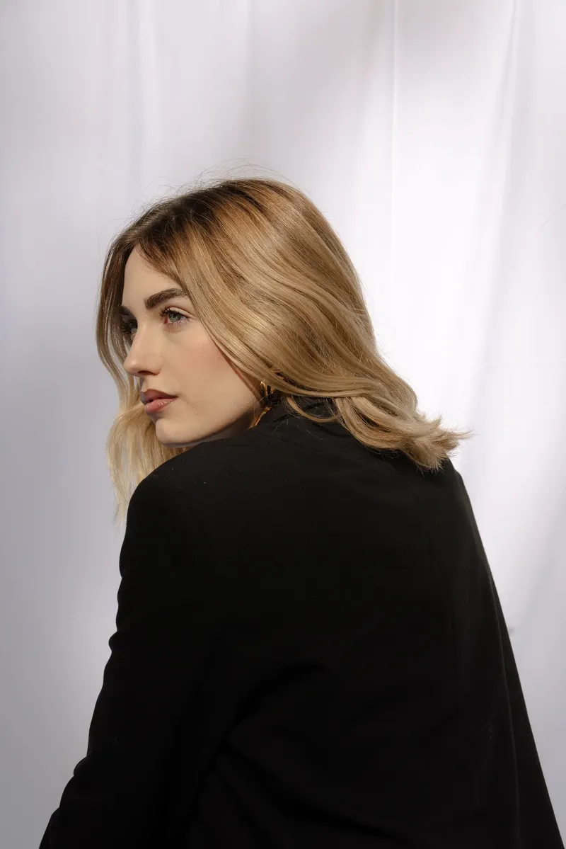 Bianco Silenzio: Alessia di spalle, capelli biondi sul blazer nero