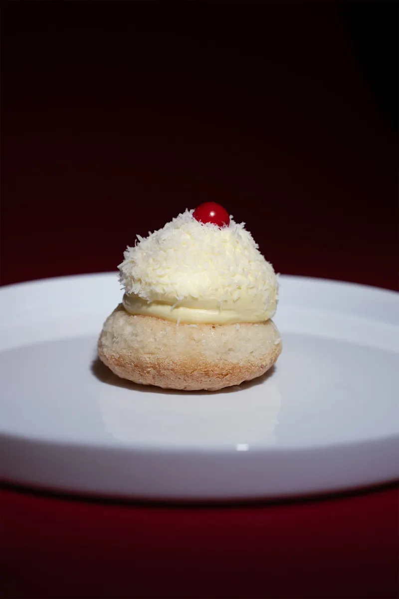 Pasticcino bianco con ribes rosso su piatto bianco